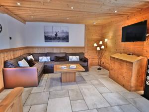 ein Wohnzimmer mit Sofa und Fernseher in der Unterkunft Charmant 3 pièces rénové avec sauna et jacuzzi pour 6 pers. au Grand-Bornand - FR-1-458-107 in Le Grand-Bornand