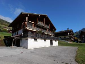 a building with a balcony on the side of it at Charmant appart. 70m², 2 chambres, mezzanine, balcon sud, garage, près commerces, navettes - FR-1-458-110 in Le Grand-Bornand
