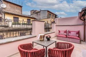 a patio with two chairs and a table on a balcony at THE STEPS Hotel - by Eitch Collection in Rome