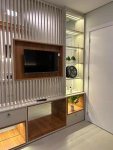 a living room with a tv on a wall at Plaza Mayor Loft in Capão da Canoa
