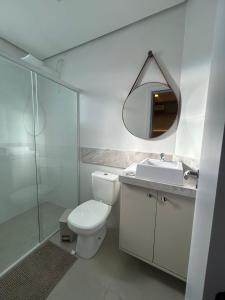 a bathroom with a toilet and a sink and a mirror at Plaza Mayor Loft in Capão da Canoa +22 photos