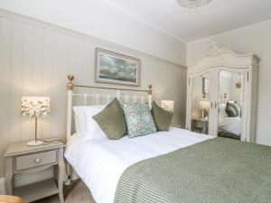 a bedroom with a large white bed and a mirror at 11A High Street in Jedburgh