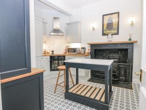 a kitchen with a table in front of a fireplace at 11A High Street in Jedburgh