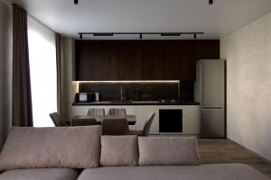 a living room with a couch and a kitchen at Pysanka apartments in Kolomiya