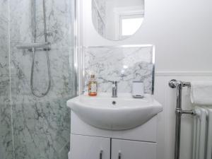 a white bathroom with a sink and a shower at 11A High Street in Jedburgh +24 photos