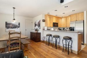 a kitchen with a table and a counter with bar stools at Snowblaze Condos Building A unit 33 in Winter Park +27 photos