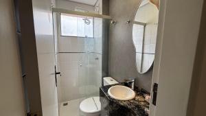a bathroom with a sink and a toilet and a mirror at Bahamas 357 - Com Garagem Coberta Gratúita in Águas Claras