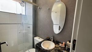 a bathroom with a sink and a toilet and a mirror at Bahamas 357 - Com Garagem Coberta Gratúita in Águas Claras