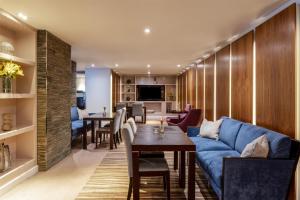 a living room with a blue couch and a table at Radisson Blu Hotel, Bristol in Bristol