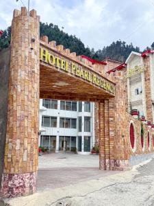 ein gemauerter Torbogen vor einem Hotelpee peraja kovalam in der Unterkunft Hotel Pearl Regency in Kalām