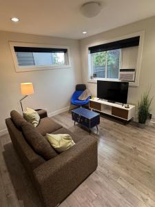 ein Wohnzimmer mit Couch und Flachbildfernseher in der Unterkunft 2 queen beds with laundry, full kitchen, walk in closet in Victoria