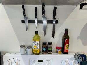 Ein Stapel Messer hängt an einer Wand über einem Herd. in der Unterkunft 2 queen beds with laundry, full kitchen, walk in closet in Victoria + 12 Fotos