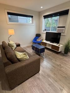 ein Wohnzimmer mit Couch und Flachbildfernseher in der Unterkunft 2 queen beds with laundry, full kitchen, walk in closet in Victoria