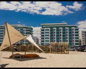 ママイアにあるRoyal Summerの背景に建物が建つビーチのテント