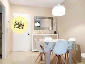 a dining room with a glass table and white chairs at Lujoso Golden Sunset in Oropesa del Mar
