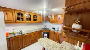 Elle comprend une petite cuisine avec des placards en bois et un évier. dans l'établissement Casa Borboleta, à Arco da Calheta