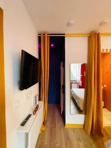 1 dormitorio con 1 cama, TV y espejo en Love Room L Osmose Sauna hammam spa à Wimereux, en Wimereux