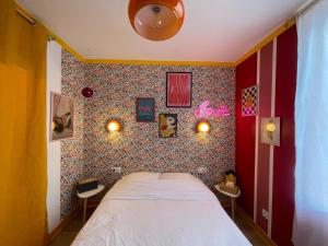 a bedroom with a bed and a wall covered in wallpaper at Love Room L Osmose Sauna hammam spa à Wimereux in Wimereux
