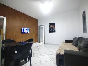 un salon avec un canapé et une télévision sur un mur dans l'établissement AP Custo benefício a 10 min de praia,rodoviária, estádio e ferroviária, à Vila Velha
