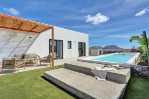a backyard with a swimming pool and a house at ISLAND WEEK Fuerteventura in La Oliva