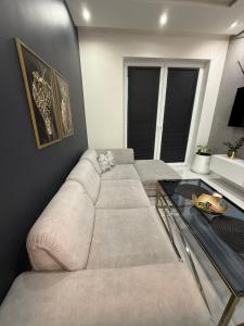 a living room with a couch and a glass table at Komfort House apartament z tarasem in Ełk