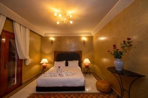 a bedroom with a bed and a vase of flowers at Domaine 3 Riads in Marrakech