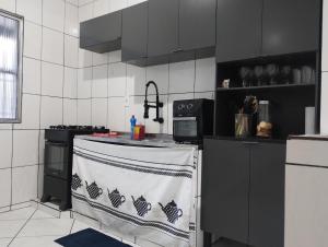 une cuisine avec des armoires noires et un comptoir avec une serviette dans l'établissement AP Custo benefício a 10 min de praia,rodoviária, estádio e ferroviária, à Vila Velha