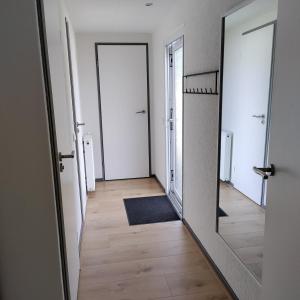 een hal met twee spiegels en een houten vloer bij Amazing nature house in Anloo