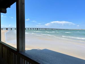 a view of the beach from a house window at Atlantis - Oceanfront Seating at its Finest! in Freeport