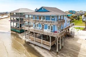 two houses on the beach next to the water at Atlantis - Oceanfront Seating at its Finest! in Freeport +38 photos