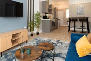 ミドルズブラにあるRio Apartmentsの青いソファとテーブルのあるリビングルーム