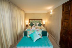 a bedroom with a bed with blue sheets and pillows at Domaine 3 Riads in Marrakech +135 photos