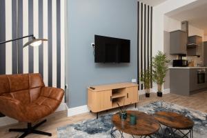 ミドルズブラにあるRio Apartmentsの椅子とテレビのあるリビングルーム