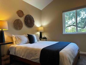 a bedroom with a bed with two lamps and a window at Creekside home with private waterfall & farm 