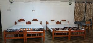 two beds sitting next to each other in a room at BeingWild Resort in Masinagudi