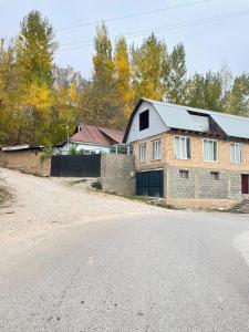 a brick house on the side of a road at Modern Homestay in Arslanbob