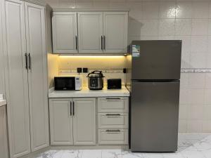 a kitchen with a refrigerator and a microwave at سويت بغرفة نوم أنيقة وواسعة ودخول ذاتي in Hail