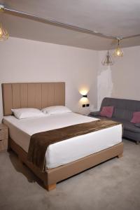 une chambre avec un grand lit et un canapé dans l'établissement History Center Hotel, à Medellín