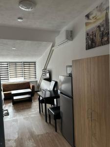 a kitchen with a refrigerator and a living room at B&B Santorini Maasbree in Maasbree