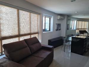 un soggiorno con divano e cucina di Flat mobiliado e bem localizado a Recife
