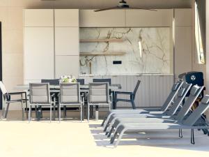 ein Esszimmer mit Stühlen und einem Tisch und einer Marmorwand in der Unterkunft Villa Horizon - 5 suites in Alhaurín el Grande