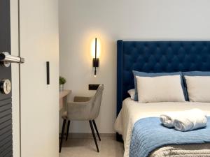 ein Schlafzimmer mit einem blauen Bett und einem Stuhl in der Unterkunft Villa Horizon - 5 suites in Alhaurín el Grande + 54 Fotos