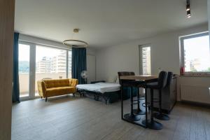a room with a bed and a table and chairs at CH Apartments Urban Plaza in Braşov
