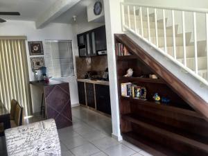 a living room with a staircase and a kitchen at Mango 78 in Playa del Carmen