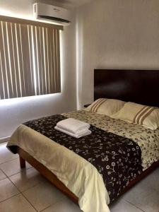 a bedroom with a bed with two towels on it at Mango 78 in Playa del Carmen