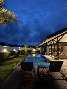 a villa with a swimming pool at night at 913 Luxury Pool Villa Khaolak in Khao Lak