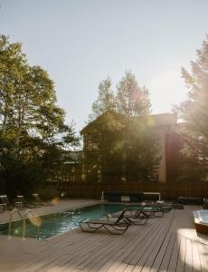 a swimming pool with chairs and a house at The Alpenhof in Teton Village