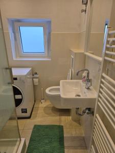 ein Bad mit einem Waschbecken und einem WC mit einem Fenster in der Unterkunft Modern Köln Flat 20mins Messe 25mins Neumarkt in Köln