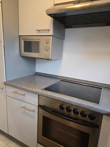 eine Küche mit Herd und Mikrowelle in der Unterkunft Modern Köln Flat 20mins Messe 25mins Neumarkt in Köln + 11 Fotos