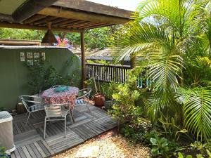 a patio with a table and chairs on a deck at Praia do Forte Kauai Bahia in Praia do Forte